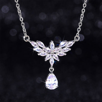 Silver marquise flower teardrop necklace on dark bokeh background