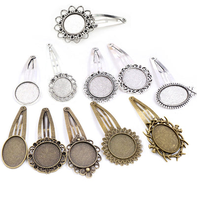 Assorted ornate round and oval bezel hair clip blanks arranged together on a plain background