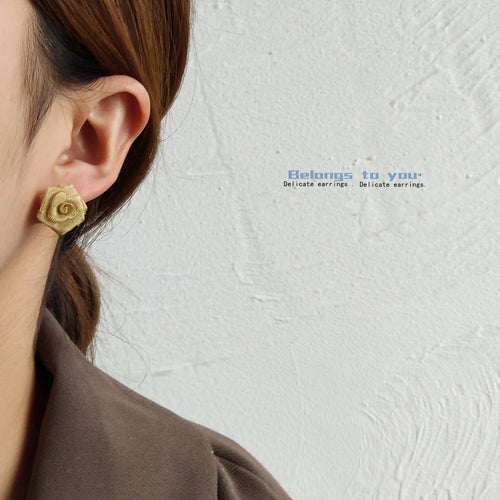 Model wearing gold mesh rose flower stud on ear