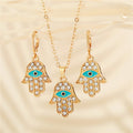 Gold Tone Crystal Hamsa Evil Eye Pendant Necklace and Huggie Earrings view 1