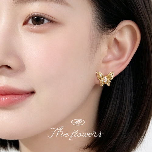 Model ear wearing gold butterfly stud with clear marquise center