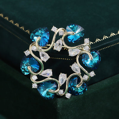 Blue heart crystal wreath brooch on dark green velvet box
