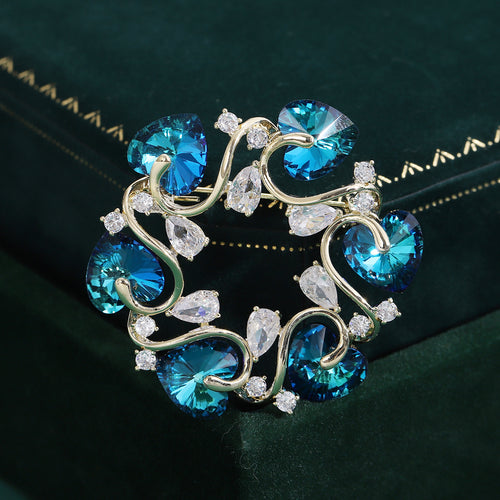 Blue heart crystal wreath brooch on dark green velvet box