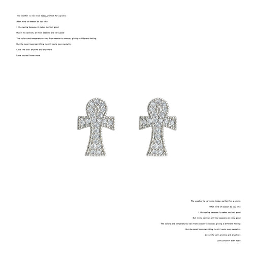 Pair of silver pave crystal ankh cross studs on white background