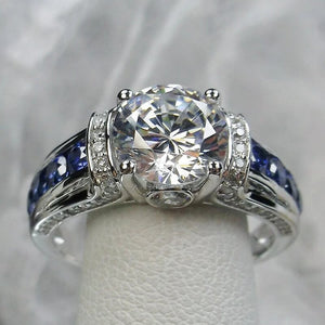 Round Clear Solitaire Blue Channel-Side Ring Silver Tone