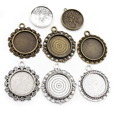 Front overview of scalloped round pendant tray settings in mixed metal tones arranged on a light background