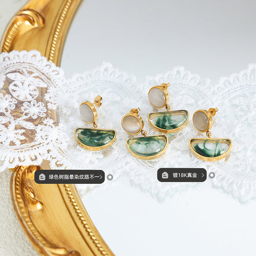 Gold cats eye green resin drop earrings on lace with material labels