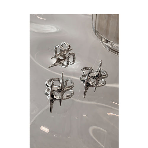 Three silver star open rings displayed on clear glass table