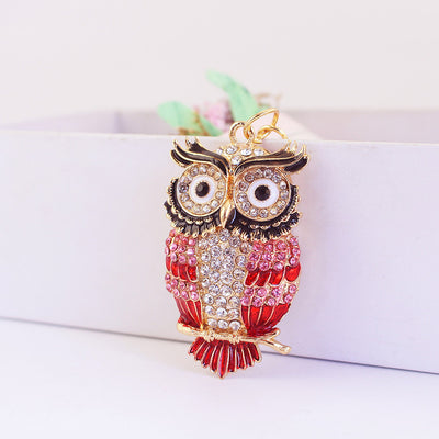 Close-up of a red owl charm covered with clear, pink, and red rhinestones.
