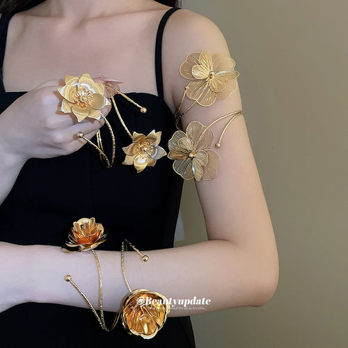 Model wearing gold dual flower spiral arm cuffs and bracelets