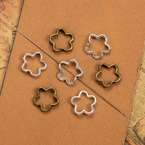 Open flower outline linking bead components displayed in multiple metal finishes