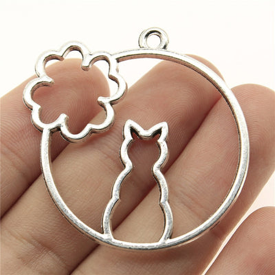 Antique Silver 猫与花圆框吊坠 displayed on fingertips
