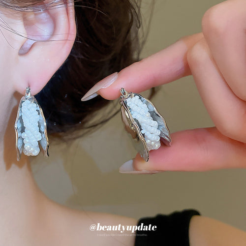 Primary view of wide rippled silver tone hoops with a curved strip of tiny white beads along the center