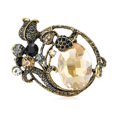 Front view of curved floral brooch centered on a large faceted oval stone