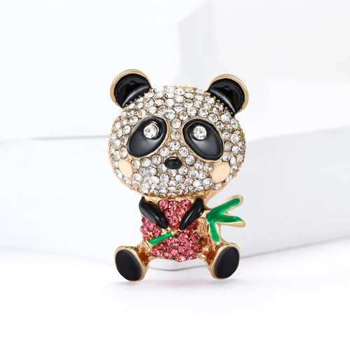 Angled display of the panda and bamboo brooch on a white surface
