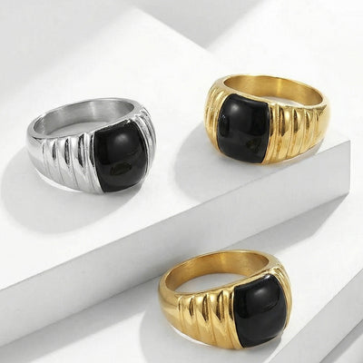 Gold and silver black enamel striped rings displayed on white blocks