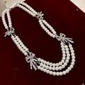 Triple Strand Faux Pearl Necklace With Crystal Bows view 2
