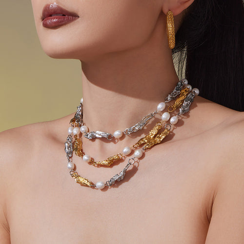 Model in multi-strand irregular metal pearl necklaces gold and steel