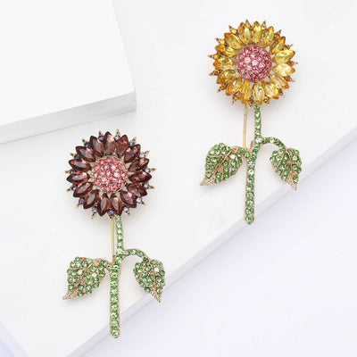 Front view of the crystal sunflower brooch showing a tall crystal sunflower with green stem and leaves