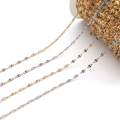 Gold-tone jewelry chain jewelry findings arranged on a light background