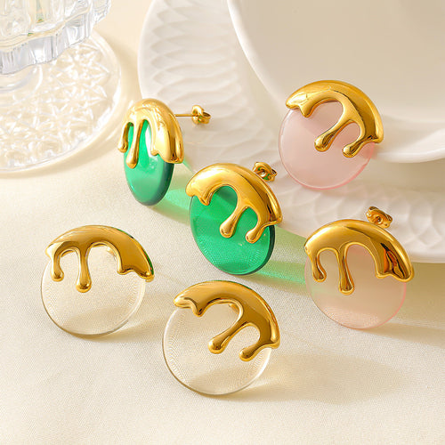 White pink and green drip resin stud earrings scattered on fabric table