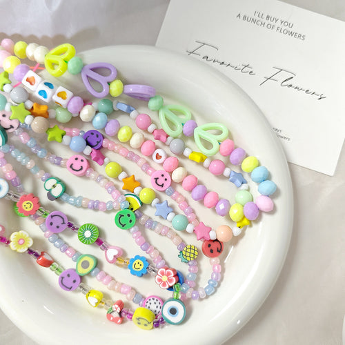 Pile of colorful mixed bead phone charms with smiles stars and hearts
