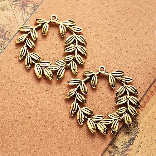 Closer view of the olive branch wreath charm surface and openwork details