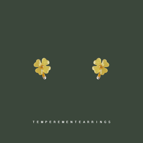 Pale green four-leaf flower studs on dark green background