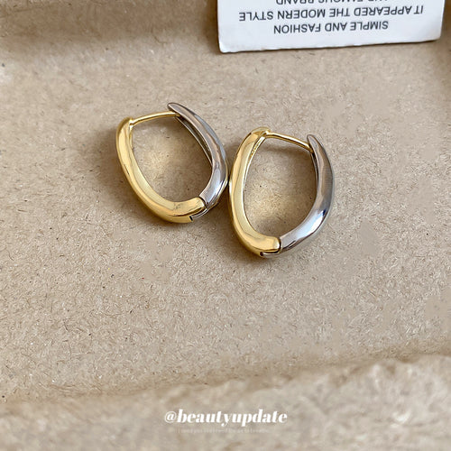 Smooth rounded U-shaped hoops combining gold and silver tone finishes displayed in a close product arrangement.