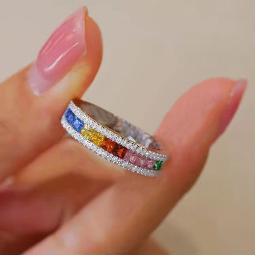Multicolor channel-set ring held between fingertips