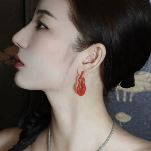 sculptural open loop stud earrings in burgundy and silver tone shown in an on-ear styling view