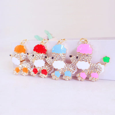 Orange, red, blue, and pink poodle charms are arranged in a row.