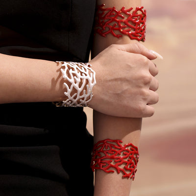Model wearing white and red coral branch enamel open cuff bracelets