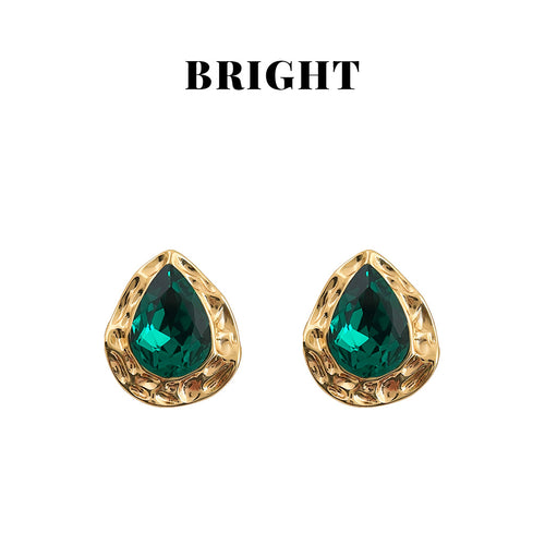 Gold hammered teardrop emerald crystal studs on white background