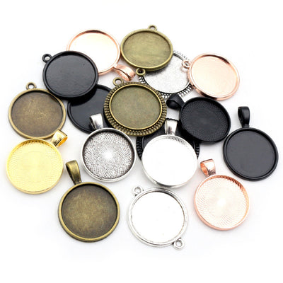 Assorted round pendant bezel trays in six mixed metal finishes arranged together on a plain background