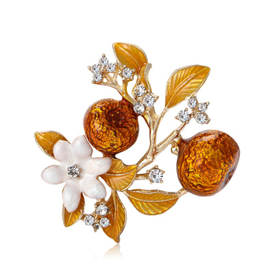 Front view of the amber crystal fruit branch brooch with white blossoms on a white background