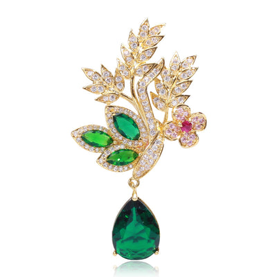 Gold green crystal leaf brooch with teardrop pendant on white