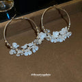 Gold Tone Hoop Earrings With White Floral and Pearl Like Accents view 2
