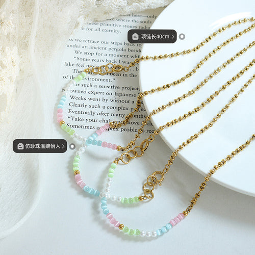 Close flat lay of pastel bead gold necklaces with 40 cm and faux pearl labels