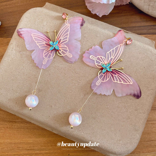 Close display of the pink fabric butterfly pearl drop earrings fashion jewelry accessory