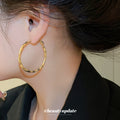 Gold Tone Twisted Oval Hoop Earrings with Detailed Finish view 3