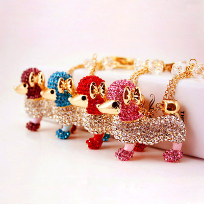 Four rhinestone poodle keychains shown together in purple, blue, red, and pink.