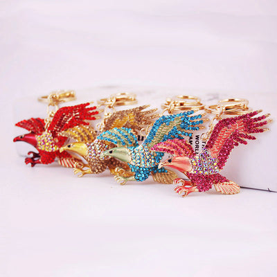 Four rhinestone eagle keychains in red, gold, blue, and pink are arranged together.