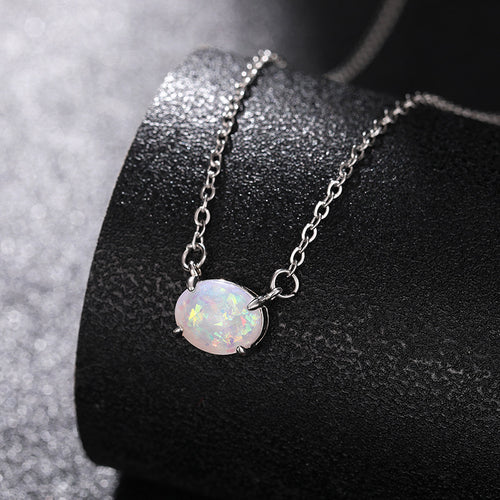 Faux opal pendant draped on black cylindrical display