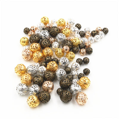 filigree round metal beads arranged together on a white background