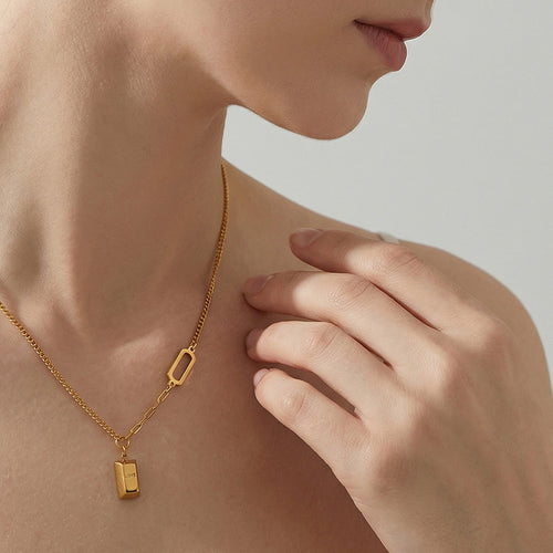Gold LOVE bar pendant necklace worn close-up on collarbone