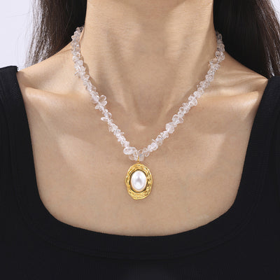 Model wearing crystal chip necklace with gold oval pearl pendant