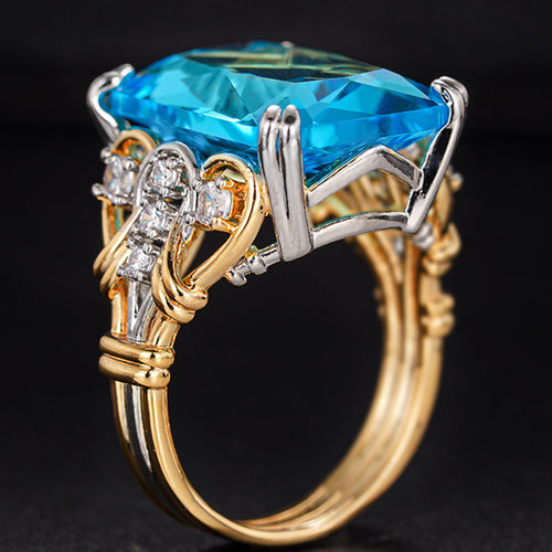 Angled view of blue rectangular stone with gold silver split shank