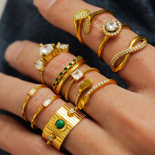 Stack of gold rings including hugging hands open ring on fingers