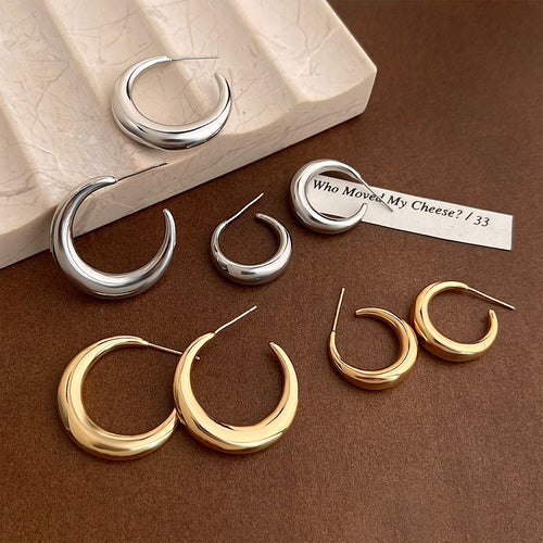 Gold and silver large and small crescent hoops on brown with marble